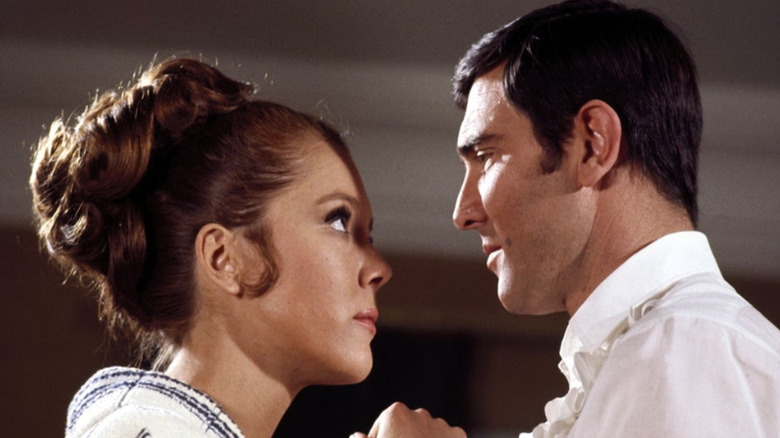 George Lazenby and Diana Rigg staring at each other