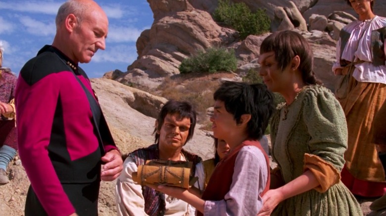 Captain Picard being presented with a gift by Mintakans in "Star Trek: The Next Generation"