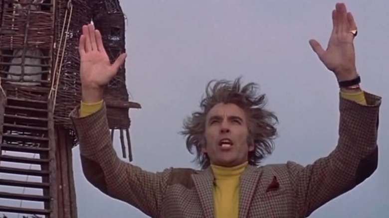 Lord Summerisle raises his hands in supplication in The Wicker Man (1973)