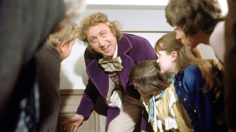 Wonka gestures towards a small door in Willy Wonka and the Chocolate Factory (1971)