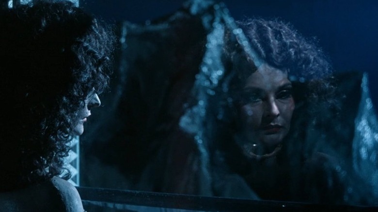 Mrs. Moses looking at her reflection on a window in Dead Mountaineer's Hotel