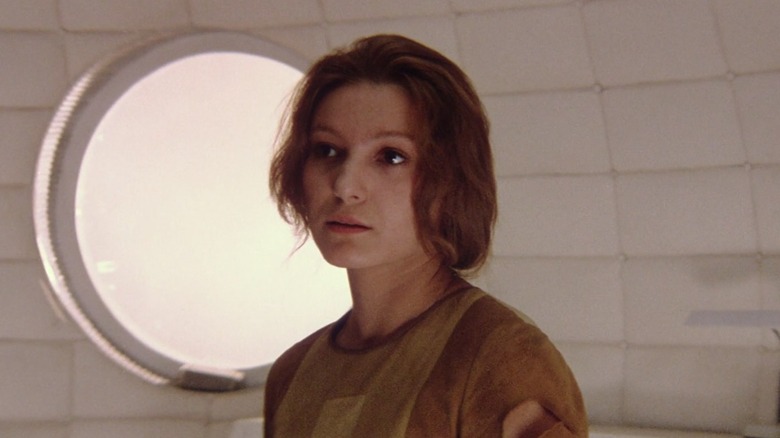 Hari standing in front of a window in Solaris