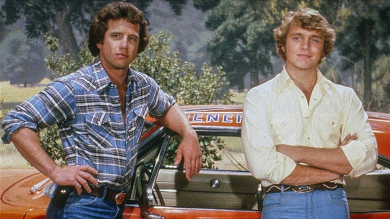 Luke and Bo Duke standing by their car