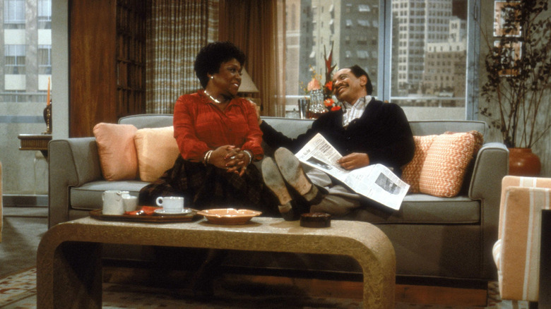 George and Louise Jefferson smiling at each other on couch