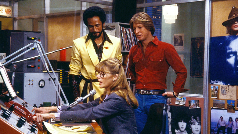 Venus and Andy standing over Bailey on the air