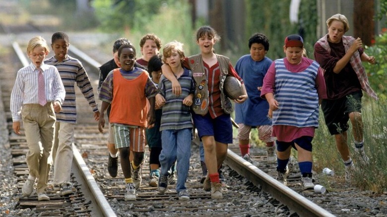 Kids walking happily on a railway
