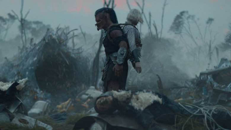 Dek and Thia wander a battlefield in "Predator: Badlands" (2025)