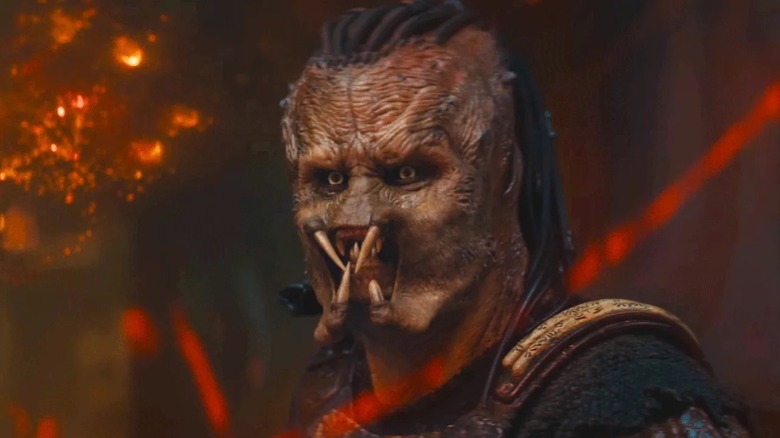 Dek next to a glistening map of Genna in "Predator: Badlands" (2025)