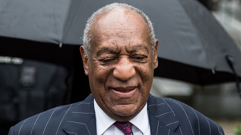 Bill Cosby walking to his court sentencing in a suit and tie