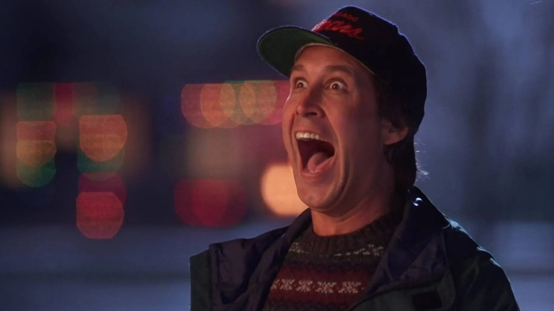 Chevy Chase as Clark Griswold in "National Lampoon's Christmas Vacation," grinning manically at his Christmas lights