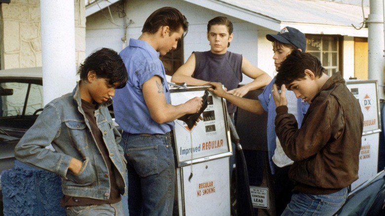 Johnny, Steve, Sodapop, Dallas, and Ponyboy standing at gas station