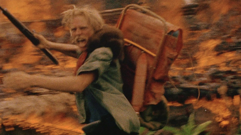 Jack Anders screaming in front of a fire in "Cannibal Holocaust" (1980)