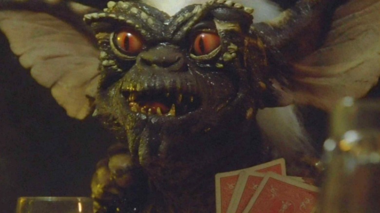 A gremlin plays cards in "Gremlins" (1984)
