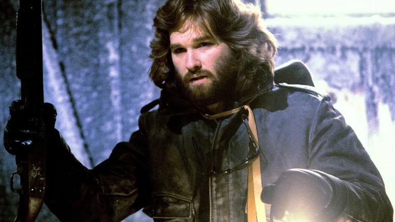 MacReady armed with a shotgun and holding a lantern in The Thing (1982)
