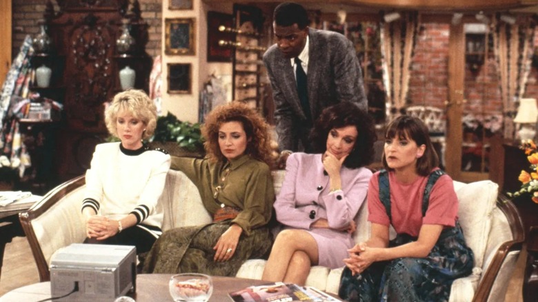 Julia and her friends, with Anthony, watching a small TV on Designing Women