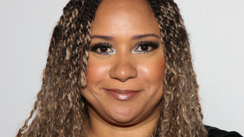 Traci Thoms smirks