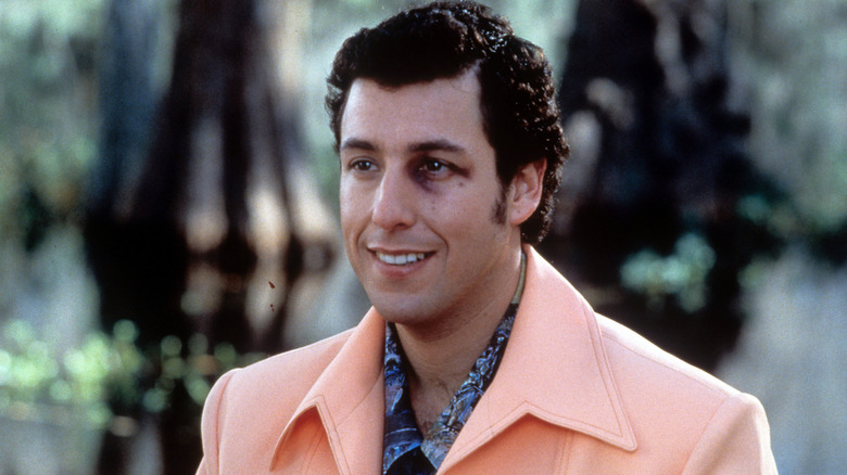 Bobby Boucher standing in a pastel, orange sport jacket and smiling despite his black eye