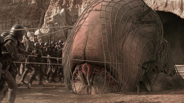 Soldiers drag the Brain Bug with a net in "Starship Troopers" (1997)