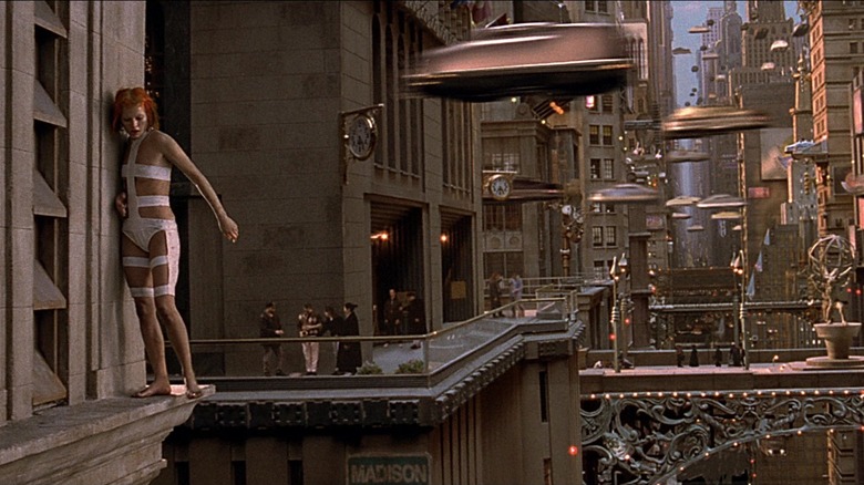 Leeloo stands on a window ledge in a futuristic city in "The Fifth Element" (1997)