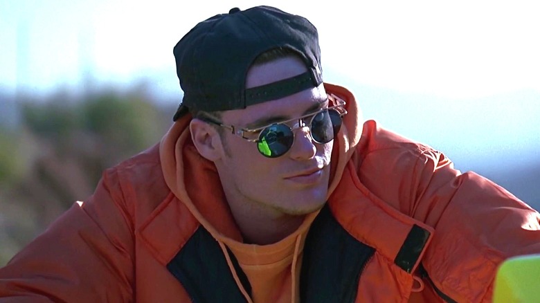 Johnny riding motorcycle in orange jacket in Cool as Ice (1991)