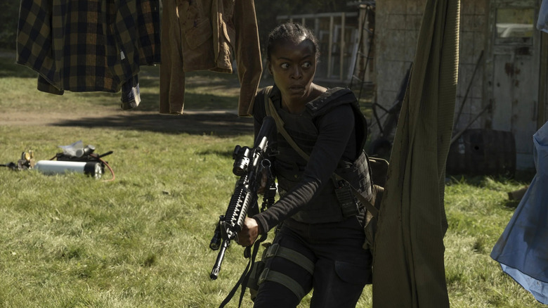Hailey Freeman looking alert with a gun in 40 Acres