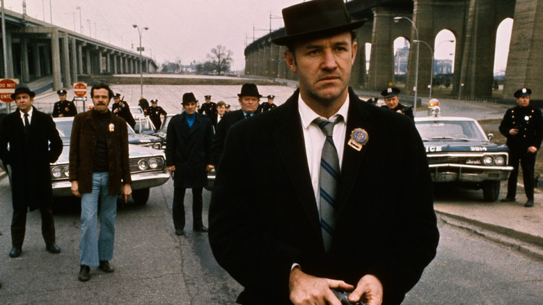 Popeye Doyle standing in front of a crowd of police in The French Connection (1971)