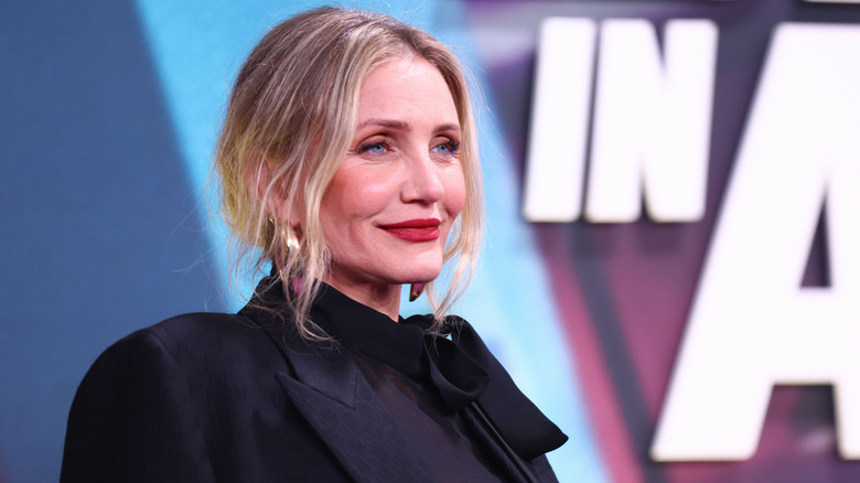 Cameron Diaz wearing red lipstick and a black outfit on the red carpet