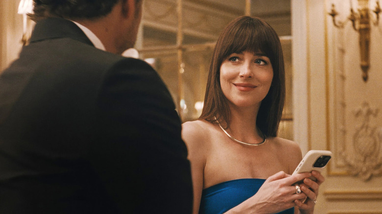 Lucy on her phone talking to Harry at a wedding in Materialists
