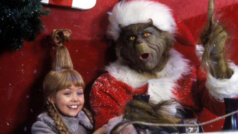 The Grinch and Cindy Lou Who ride in a sleigh in 