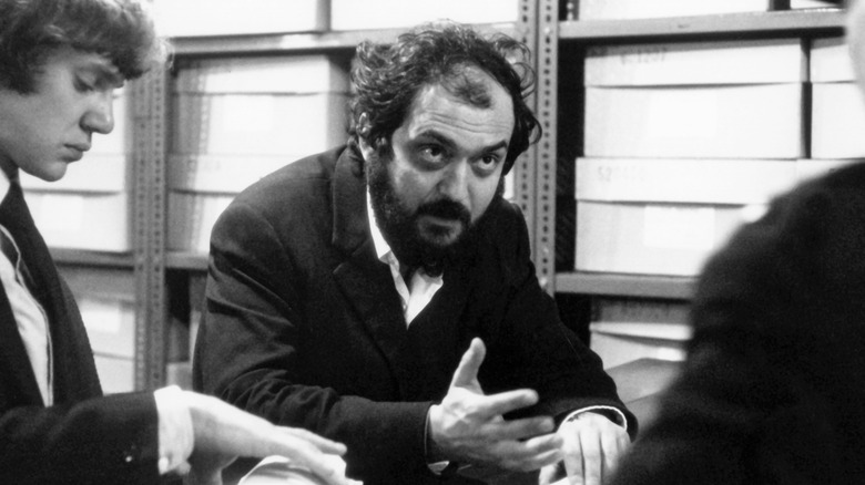 Stanley Kubrick on set next to Malcolm McDowell talking to third person (1971)