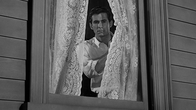 Norman Bates behind lace curtains