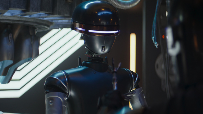 Droid bartender talking to the Mandalorian