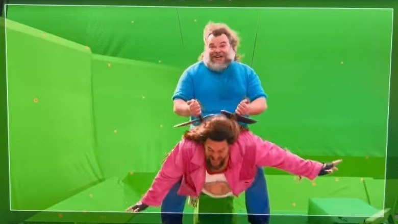 Jack Black riding Jason Momoa in front of a green screen for A Minecraft Movie