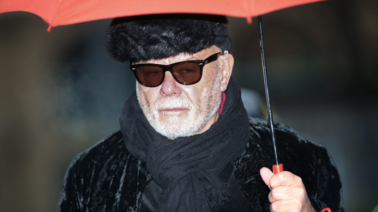 Gary Glitter holding an umbrella