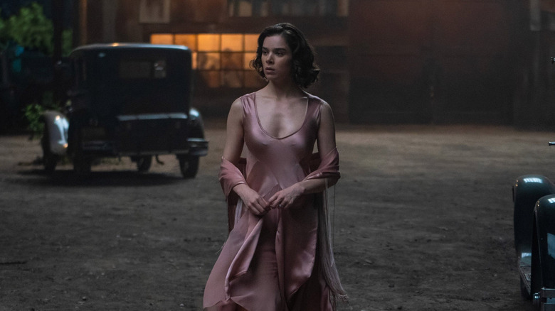 Mary walking outside of the juke joint in her pink dress in Sinners