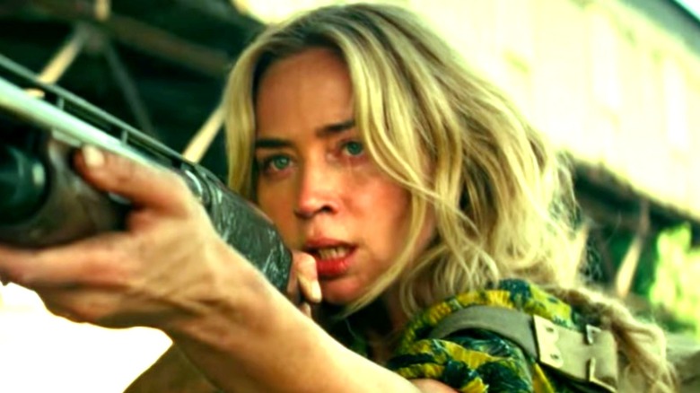 Emily Blunt pointing shotgun