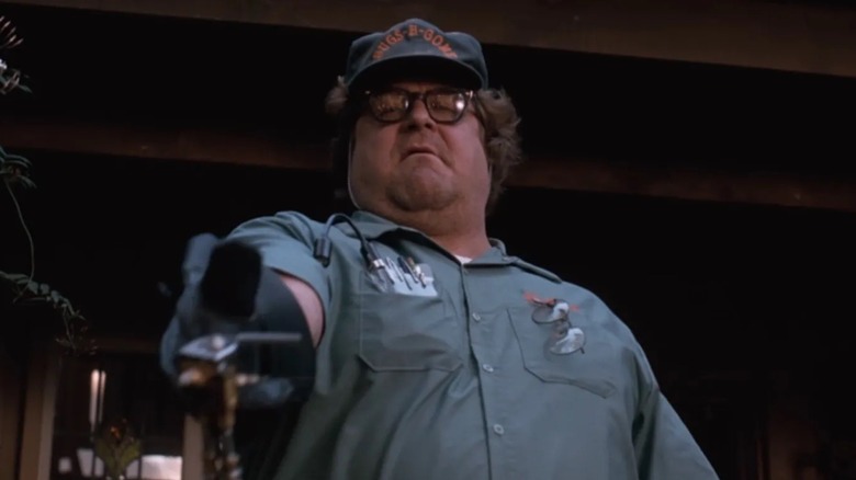 McClintock aims a spray gun towards the ground in Arachnophobia
