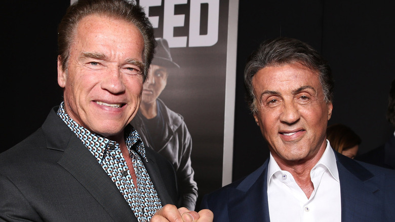 Arnold Schwarzenegger and Sylvester Stallone joining hands