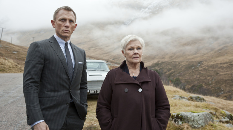 James Bond and M standing beside each other on a country road in Skyfall (2012)