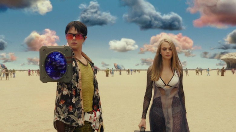 Valerian and Laureline wield a weird device in Valerian and the City of a Thousand Planets (2017)