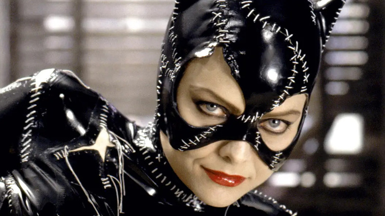 Catwoman dressed in costume and laying on a bed
