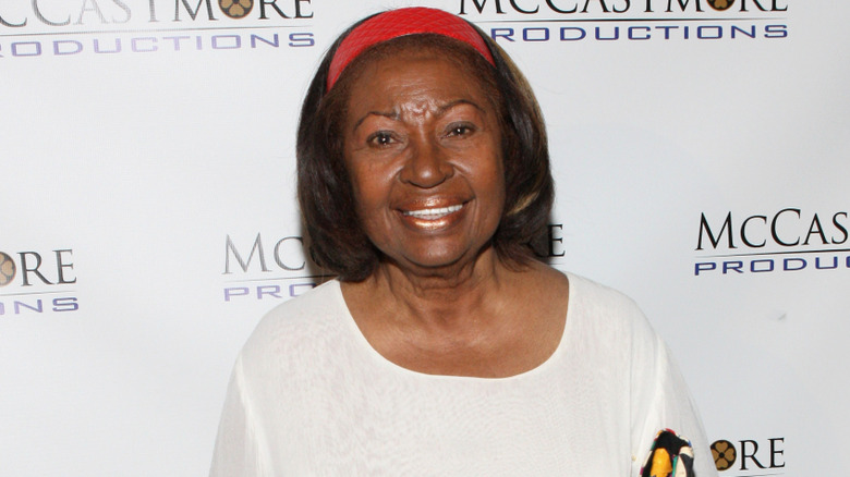 Lynn Hamilton in red headband and white shirt