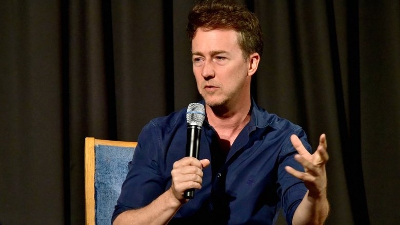 Edward Norton speaking with a microphone at an event