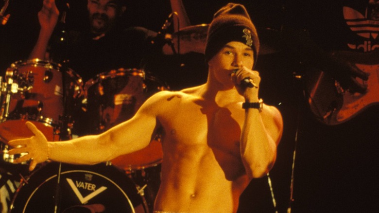 A shirtless Mark Wahlberg performing onstage in front of a drumset
