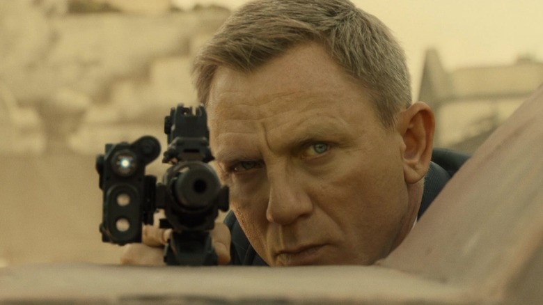 James Bond peering over rifle (2015)