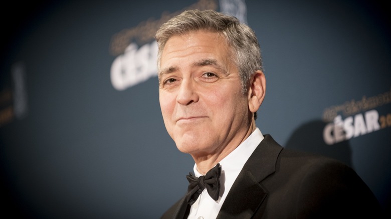George Clooney in front of a backdrop for the Cesar Awards