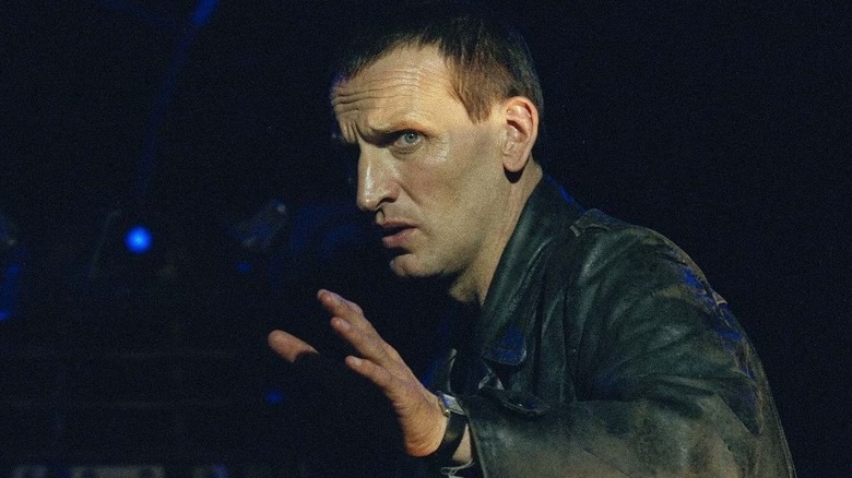 Christopher Eccleston's Doctor Who holds up his hand to plead with an enemy