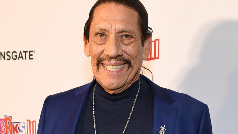 Danny Trejo smiling in blue suit