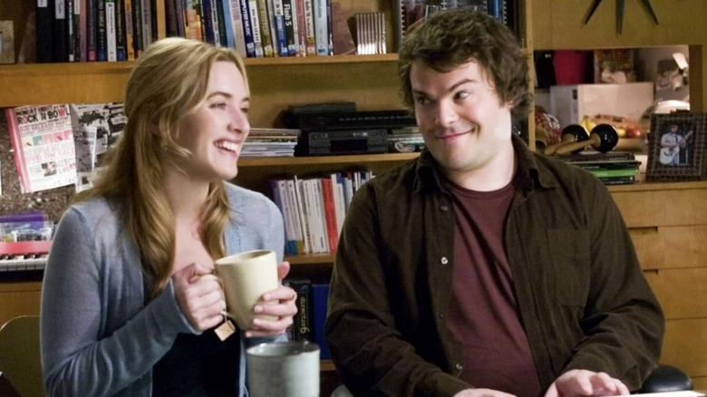 MIles smiles at Iris while seated at a desk in "The Holiday" (2006)