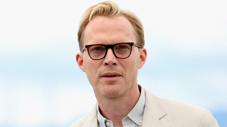 Paul Bettany wearing glasses with the sky behind him